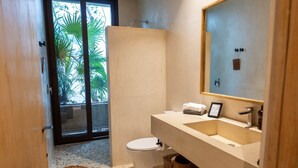 A bathroom with a white toilet, a beige sink, and a large mirror. - Room with Private Terrace and Pool |• TEVA 4B (Tulum)