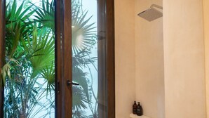 A bathroom with a glass door, a shower, and a shelf with toiletries. - Room with Private Terrace and Pool |• TEVA 4B (Tulum)