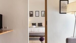 A hotel room with a bed, a small table with a potted plant, and a lamp. - Cozy · Cozy apartment great location (Mexico City)