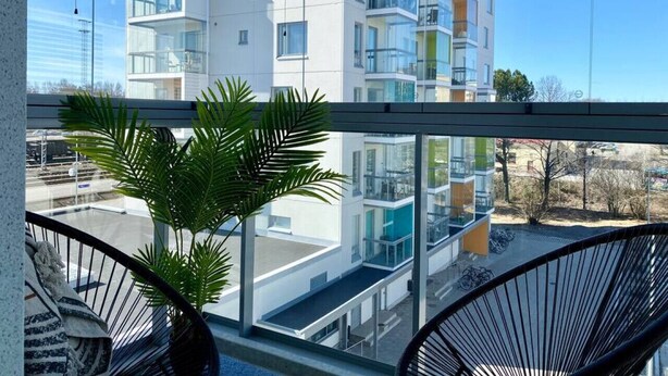 A modern apartment building with balconies, large windows, and a view of the street. - Borg Housing Travel Center (Pori)