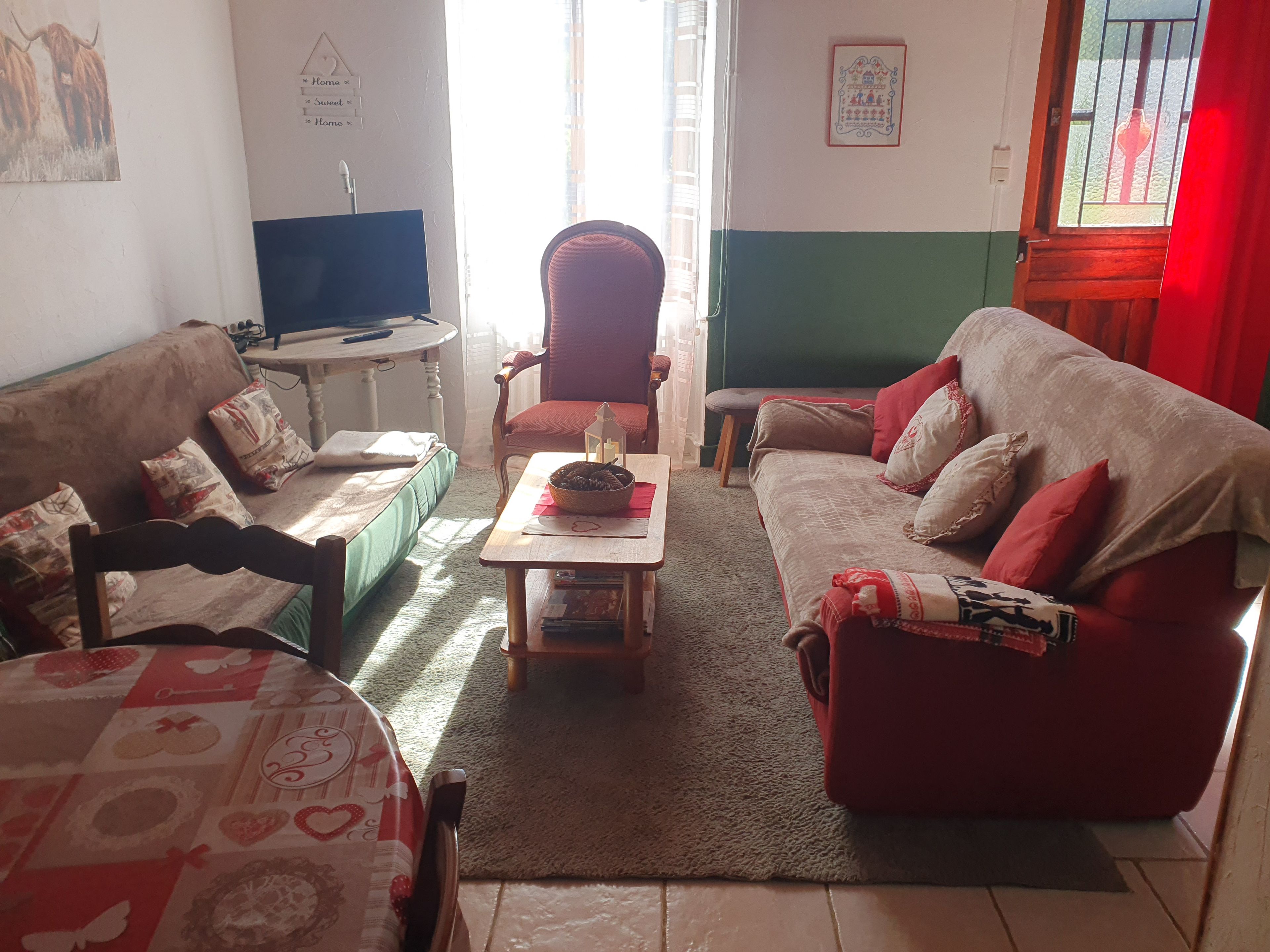 Un salon comprenant un canapé, un fauteuil et une petite table sur laquelle se trouve un panier.