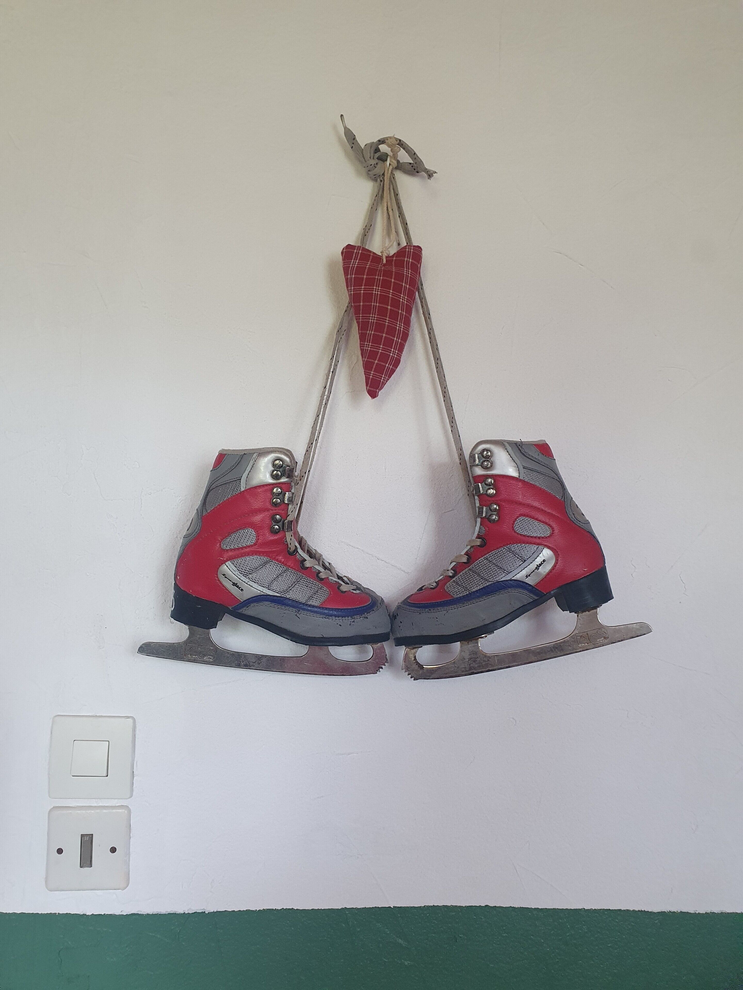 A pair of ice skates hanging on a wall.