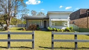 A modern two-story house with a front yard, a small porch, and a brick extension on the right. - Huskisson Delight! by Experience Jervis Bay (Huskisson)