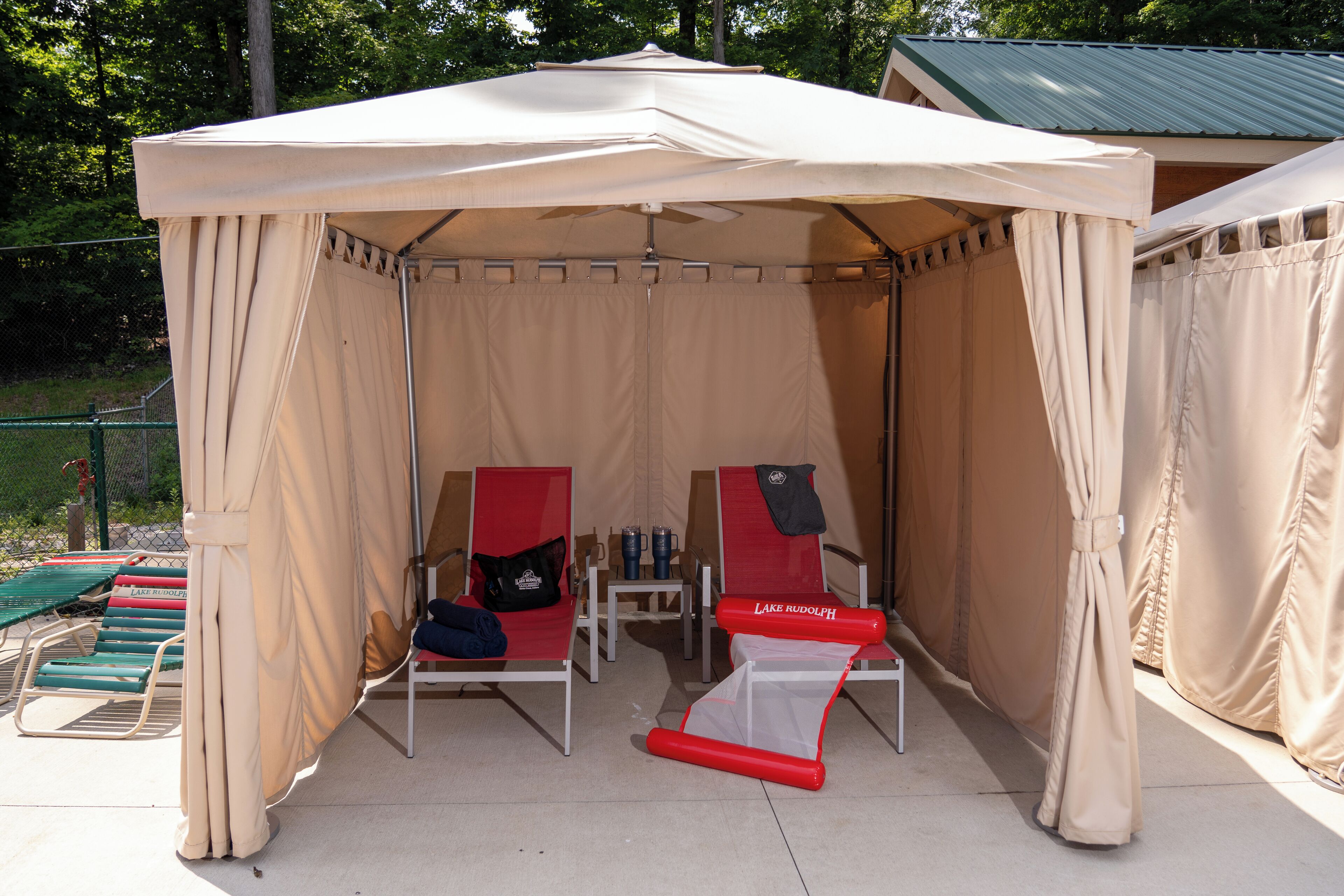A tent with two red chairs and a small table inside.