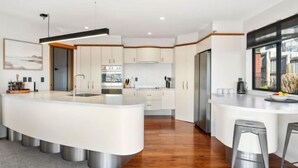A modern kitchen with a central island, stainless steel appliances, and a large window providing natural light.