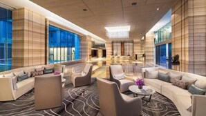 A spacious lobby with a modern design, featuring a central seating area with sofas and armchairs, a patterned carpet, and large windows offering views of the outside. - Ascott Heng Shan Shanghai (Shanghai)
