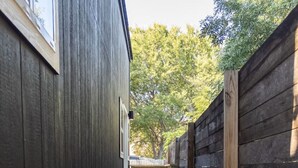 Un étroit sentier bordé de clôtures en bois mène à une porte en bois.