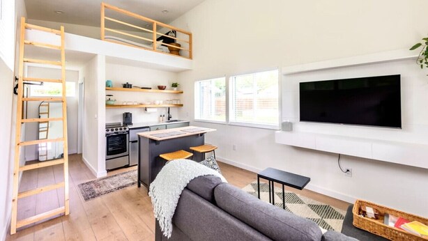 A modern loft apartment with a kitchen, dining area, and living room. - Extended Stay Retreat: Cozy yet Spacious Tiny Gem! (Austin)