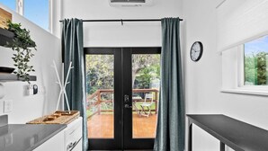 A modern kitchen with a black door leading to an outdoor deck.