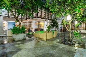 Ein Innenhof mit Sitzbereichen, einem Wasserspiel und einer Rezeption.