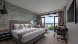 Una habitación de hotel moderna con una cama grande, un escritorio y vistas al océano.