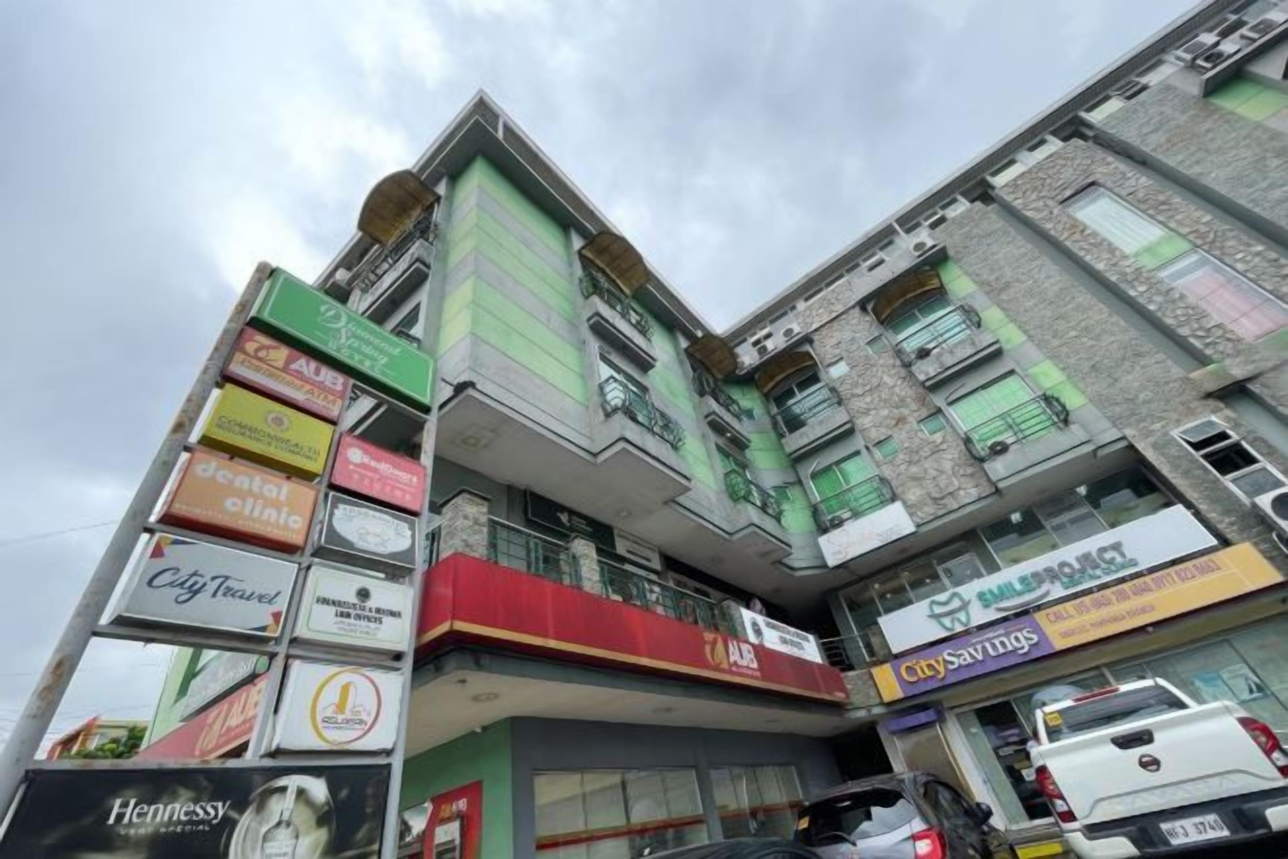 A multi-story building with various commercial signs, including a dental clinic and a travel agency.