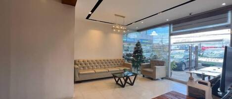 A modern interior with a sofa, a coffee table, and a wooden dining table.