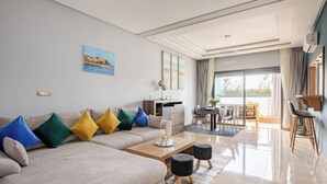 Een moderne woonkamer met een bank, salontafel en eethoek.