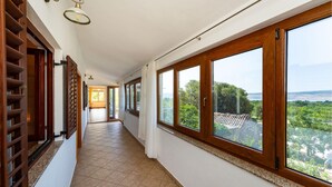 A corridor with large windows, a wooden door, and a tiled floor. - Beautiful apartment in Seline with WiFi (Seline)