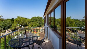 A balcony with outdoor seating, a bottle of wine, and a glass. - Beautiful apartment in Seline with WiFi (Seline)