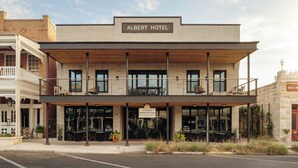 A hotel with a sign reading 'Albert Hotel' and another sign for 'Cross Mountain.' - Albert Hotel (Fredericksburg)
