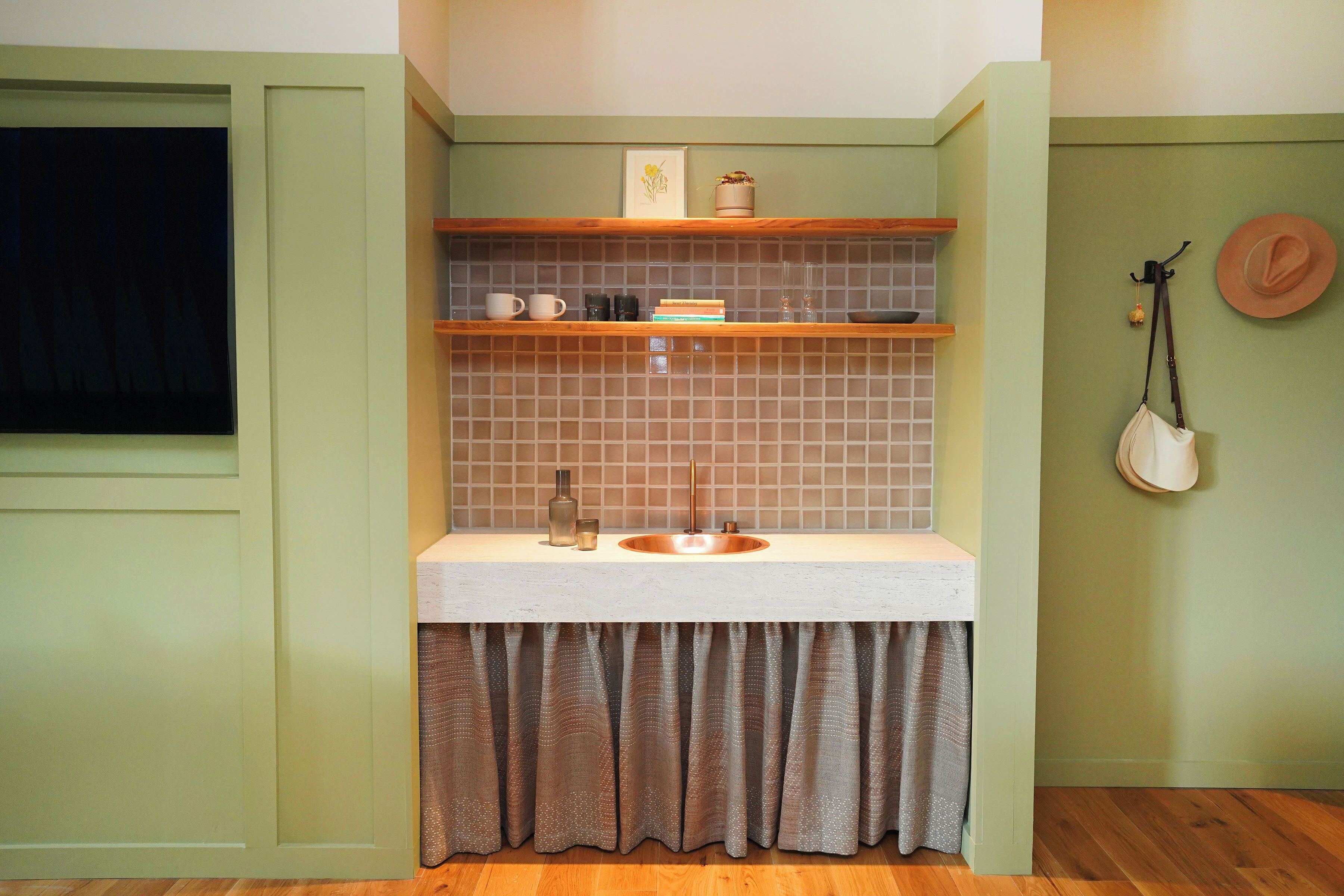 A bathroom with a sink, shelves, and a mirror.