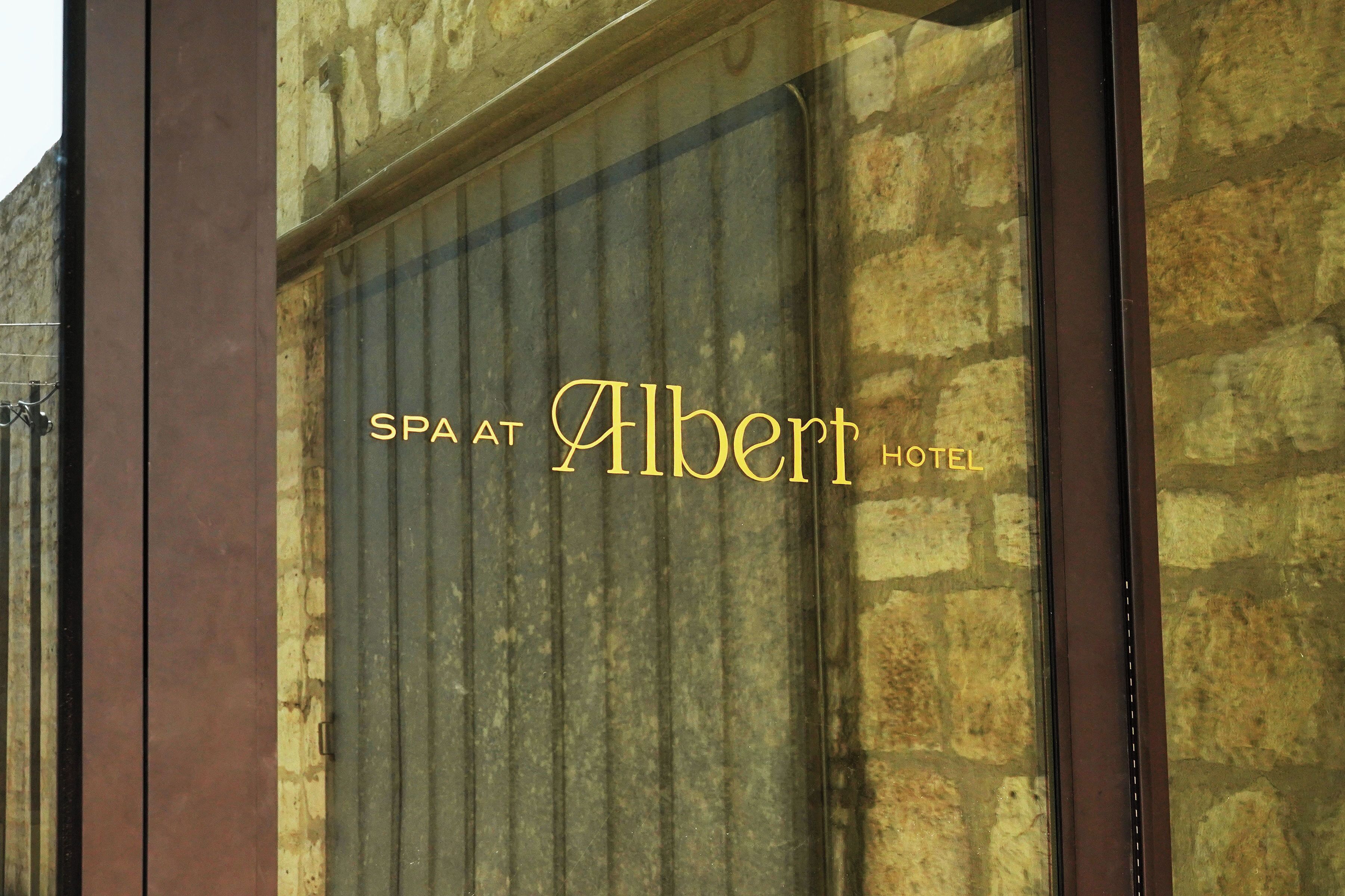 A sign with the text "SPA AT Albert Hotel" on a building facade.