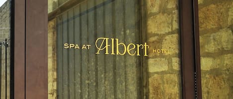 A sign with the text "SPA AT Albert Hotel" on a building facade.