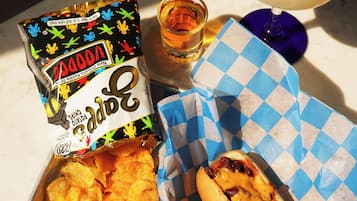 Et måltid med nachos, hotdog og margarita på et bord.