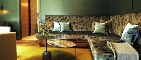 A living room with a sofa, a coffee table, and a door.