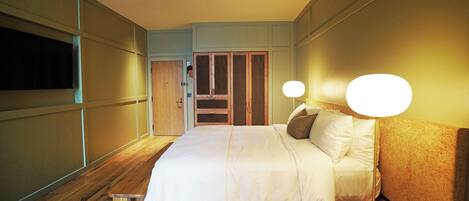 Une chambre à coucher bien rangée, avec un lit, des tables de chevet et une lampe.