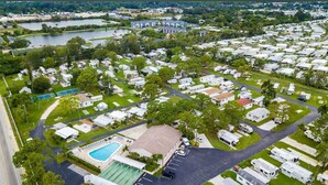 En vy från ovan över en campingplats med husbilar, en swimmingpool och en stor byggnad.