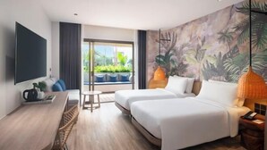 Habitación de hotel con dos camas, un escritorio, un televisor y un ventanal con vistas a la vegetación.