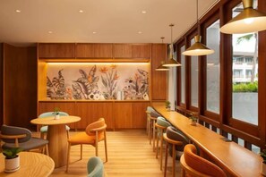 A restaurant interior with wooden paneling, round tables, and pendant lighting. - Amari Bangsaen (Chon Buri City)
