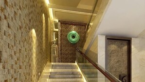 Een trap met een patroon in de muur, een leuning en een deur met een nummer.