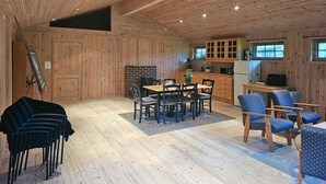 Un interior de madera con comedor, cocina y zona de estar.