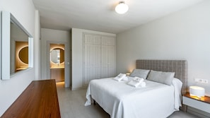 A modern bedroom with a bed, bedside table, and a wardrobe.