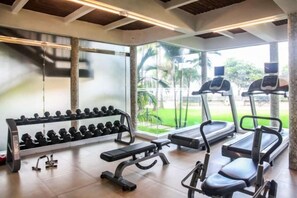 A gym with treadmills, dumbbells, and benches. - Ramada Resort Cochin (Kochi)