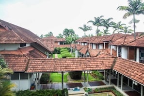 A residential area with multiple houses featuring red-tiled roofs and a central courtyard with greenery. - Ramada Resort Cochin (Kochi)