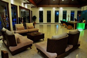 A spacious lobby with a sofa set, a reception desk, and a large window. - Ramada Resort Cochin (Kochi)
