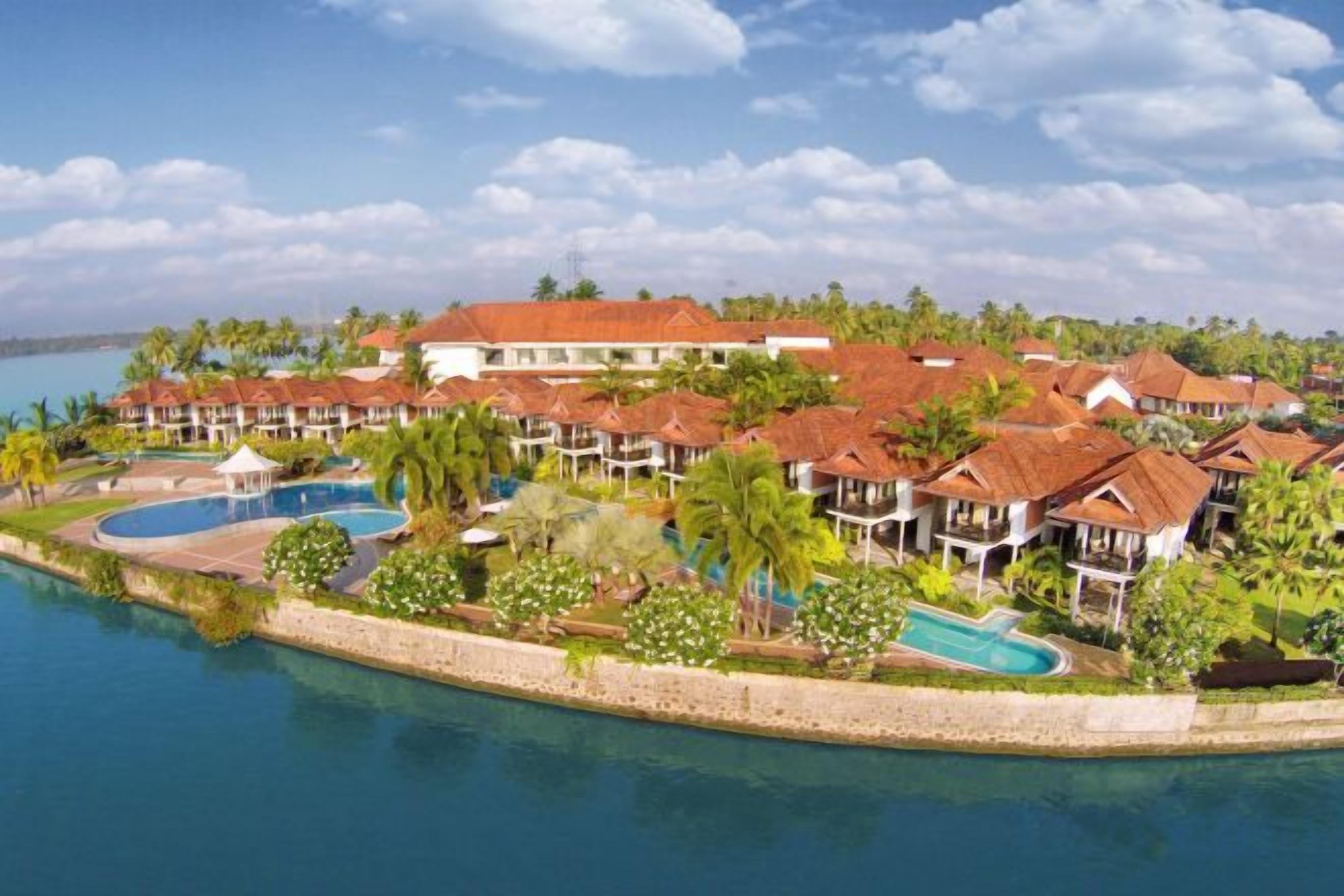 A resort with multiple buildings, a swimming pool, and a beachfront.