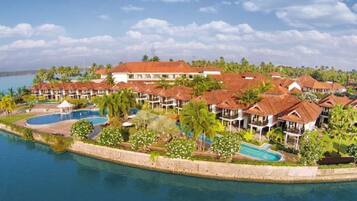 A resort with multiple buildings, a swimming pool, and a beachfront.