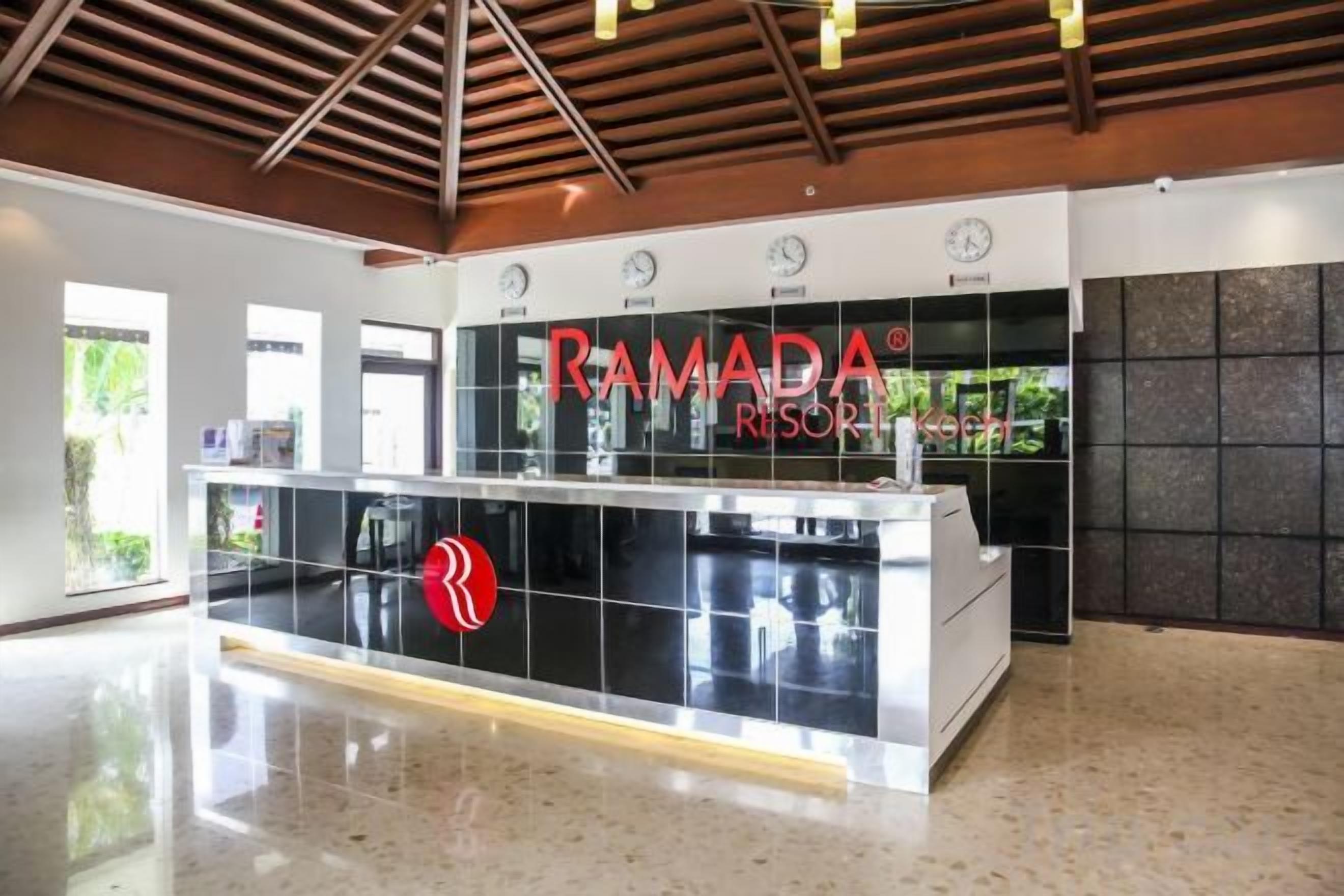 Un mostrador de recepción de diseño moderno, con un logotipo y el nombre 'RAMADA RESORT'.