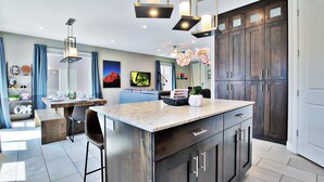 A modern kitchen with dark wood cabinets, a granite countertop, and pendant lighting. - Entrada at Moab 623 (Moab)