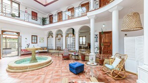 A spacious indoor courtyard with a fountain, seating areas, and a wooden door. - Beautiful home in Saint-Cyr-Sur-Loire (Saint-Cyr-Sur-Loire)