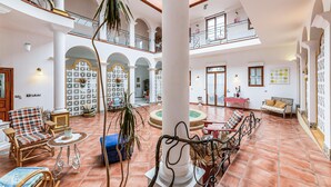 A spacious atrium with high ceilings, a central fountain, and multiple seating areas. - Beautiful home in Saint-Cyr-Sur-Loire (Saint-Cyr-Sur-Loire)