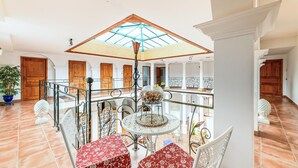 A spacious indoor area with a glass ceiling, a round table with chairs, and a decorative glass bowl on the table. - Beautiful home in Saint-Cyr-Sur-Loire (Saint-Cyr-Sur-Loire)