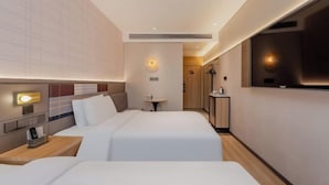A hotel room with two beds, a small table, a bedside lamp, and a view of the hallway. - Homeinn Plus Hotel (Shanghai Bund Nanjing Road Pedestrian Street) (Shanghai)