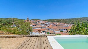 A coastal village with terracotta-roofed buildings, a wooden deck, and a swimming pool. - El Risco del Lomero Valdelarco by Ruralidays (Huelva)