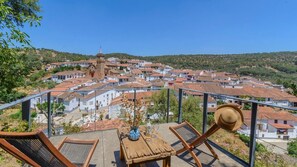 A terrace with a view of a hillside village, including a prominent church tower. - El Risco del Lomero Valdelarco by Ruralidays (Huelva)