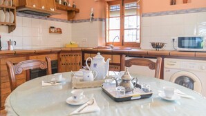 A round dining table with a tray of tea set, including cups, saucers, and a teapot. - Huerta Segura Antequera by Ruralidays (Málaga)