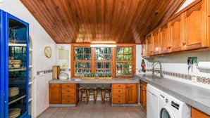 A kitchen with wooden cabinets, a sink, and a washing machine.