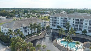 A resort with a swimming pool, palm trees, and a fountain. - CHOSEN BONITA'S FAVORITE and VRBO's PREMIER HOST with 85" TV and  2 KING BEDS! (Bonita Springs)