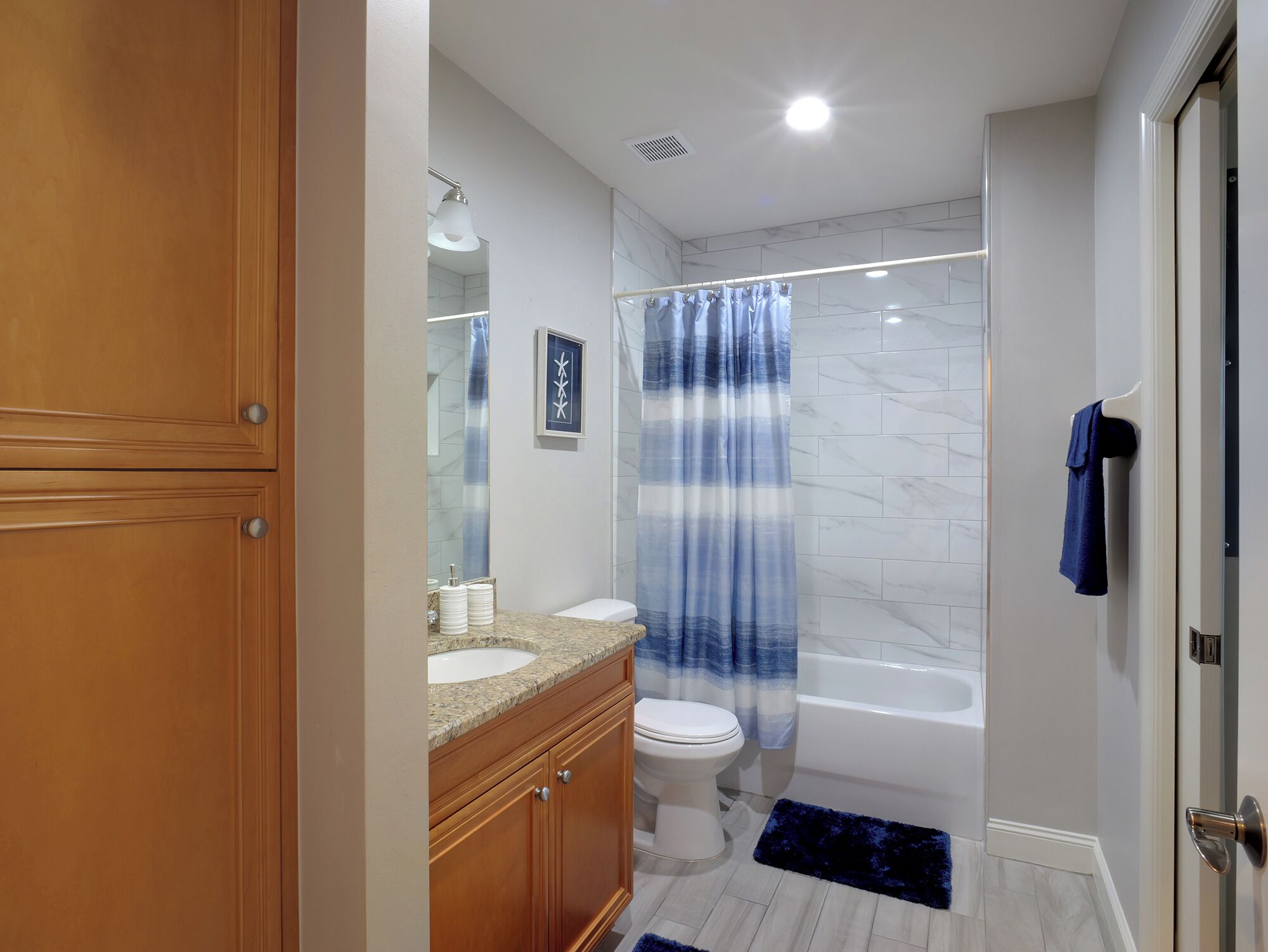 A modern bathroom with a vanity, toilet, and bathtub.